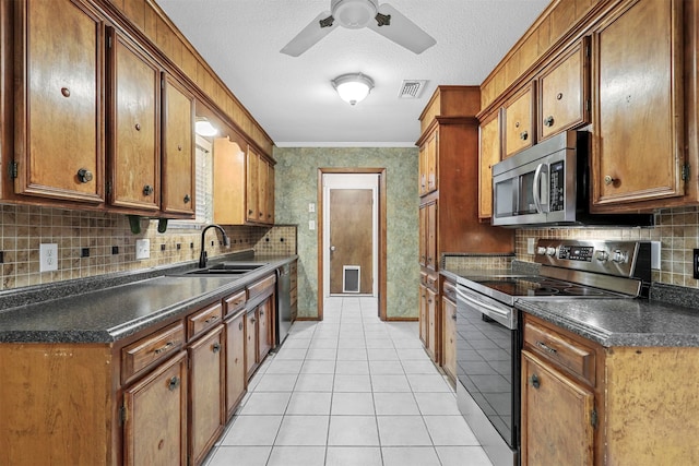 kitchen featuring appliances with stainless steel finishes, sink, tasteful backsplash, and light tile patterned flooring