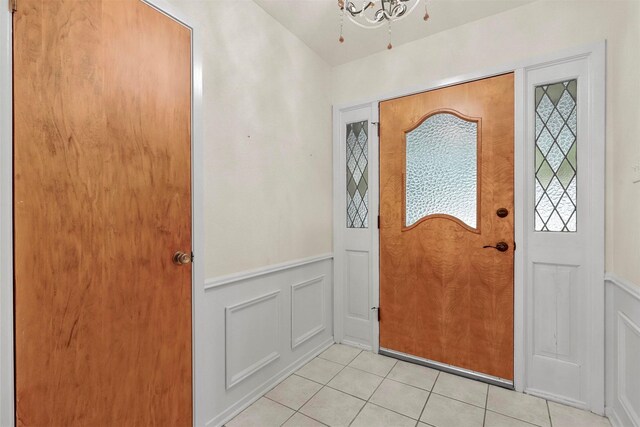 entrance foyer featuring light tile patterned flooring and a chandelier