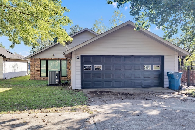 view of front facade with a front lawn, a garage, and central AC unit