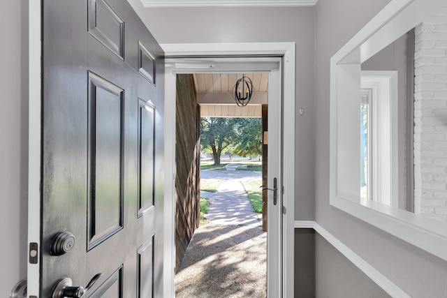 carpeted foyer entrance with plenty of natural light and ornamental molding