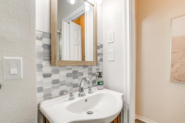 bathroom featuring sink and backsplash