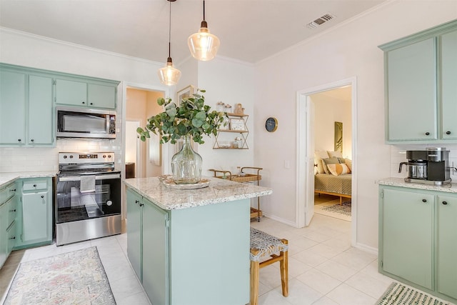 kitchen with tasteful backsplash, a center island, green cabinetry, and appliances with stainless steel finishes