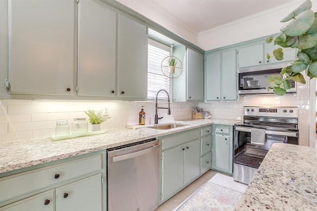 kitchen featuring sink, light tile patterned floors, appliances with stainless steel finishes, backsplash, and ornamental molding