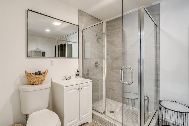 bathroom featuring vanity, toilet, and a shower with shower door