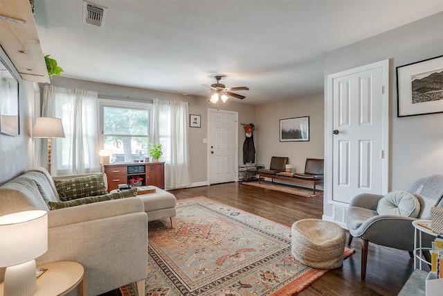 living room featuring ceiling fan and dark wood-type flooring