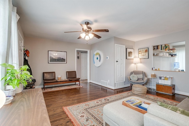 living room featuring ceiling fan and dark hardwood / wood-style flooring