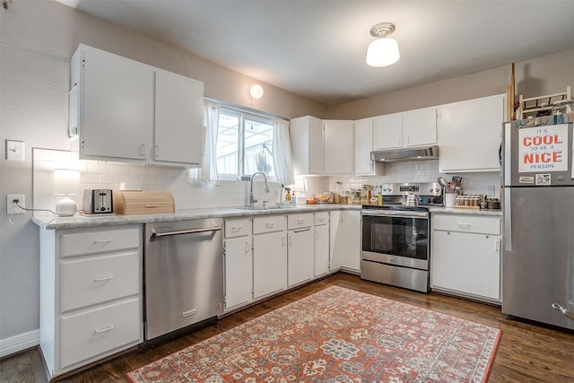 kitchen with white cabinetry, sink, dark wood-type flooring, tasteful backsplash, and appliances with stainless steel finishes