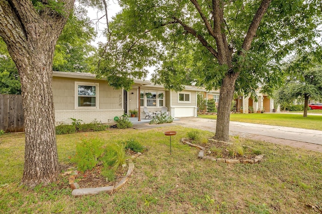 single story home with covered porch, a front yard, and a garage