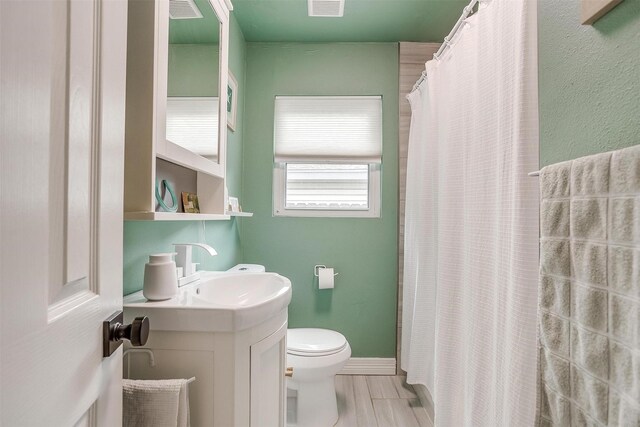 bathroom featuring vanity, a shower with shower curtain, and toilet