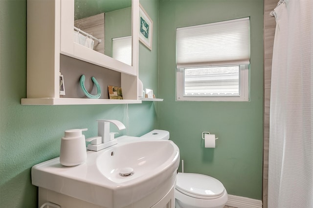 bathroom with a shower with shower curtain and toilet