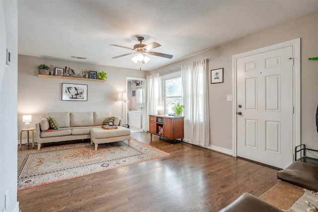 living room with dark hardwood / wood-style floors and ceiling fan