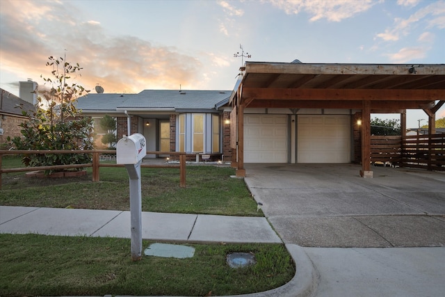 view of front of home featuring a yard, a garage, and a carport