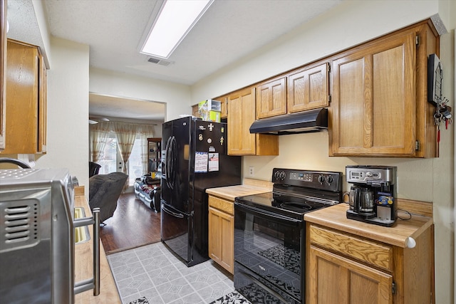 kitchen featuring light wood-type flooring and black appliances