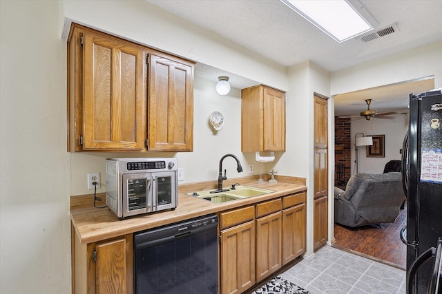 kitchen with black appliances, sink, light hardwood / wood-style flooring, ceiling fan, and a textured ceiling