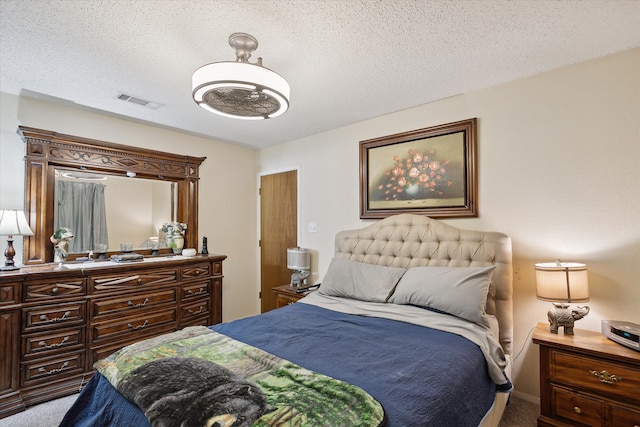 bedroom featuring a textured ceiling and light carpet