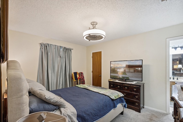 bedroom with a textured ceiling and light carpet