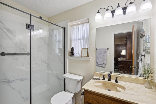 bathroom with a shower with door, vanity, a textured ceiling, and toilet