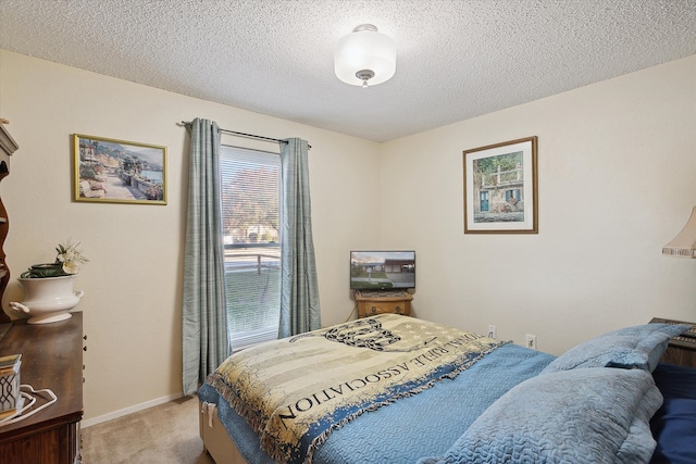 bedroom with light colored carpet and a textured ceiling