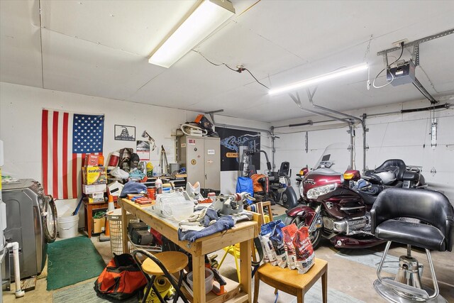 garage featuring washer / dryer, a workshop area, and a garage door opener