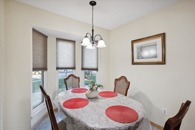 dining area featuring a textured ceiling and an inviting chandelier