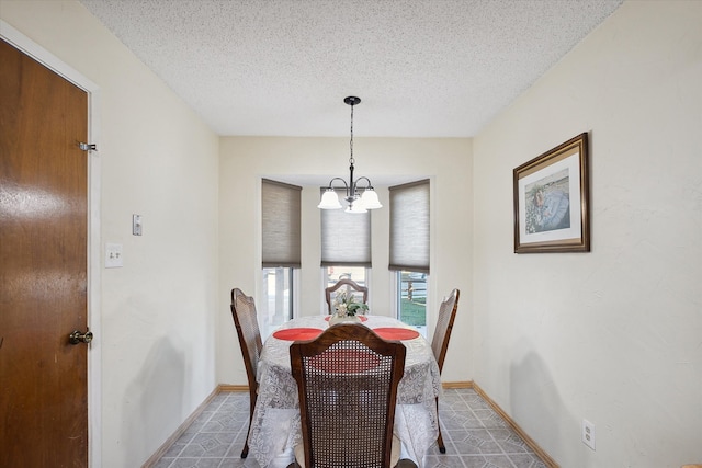 dining area with a textured ceiling and an inviting chandelier