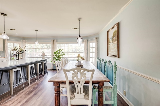 dining space with crown molding and wood-type flooring