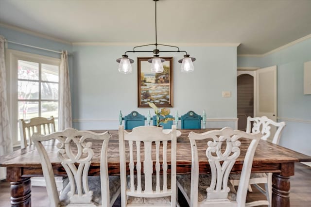 dining space featuring wood-type flooring and crown molding