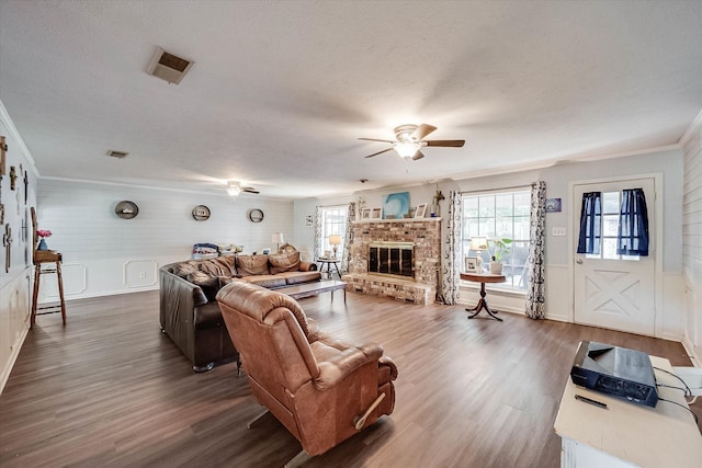 2225 W Park Ave, Corsicana, TX 75110 - living room with a ceiling fan, dark wood-type flooring, ornamental molding, a brick fireplace, and a textured ceiling