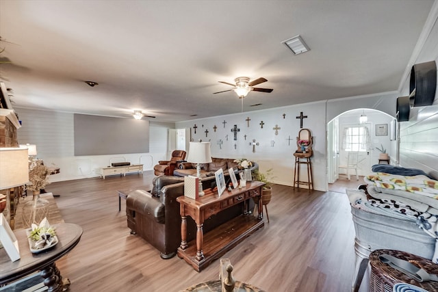 living room with hardwood / wood-style flooring, ceiling fan, and crown molding