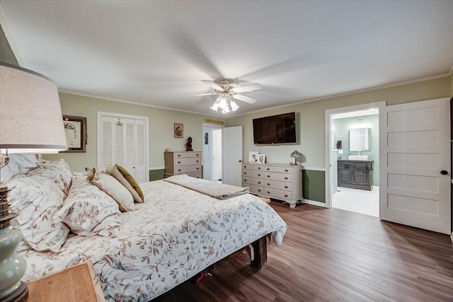 bedroom featuring ceiling fan, dark wood-type flooring, crown molding, ensuite bathroom, and a closet