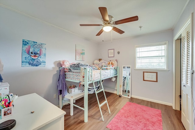 bedroom with wood-type flooring, ceiling fan, and ornamental molding