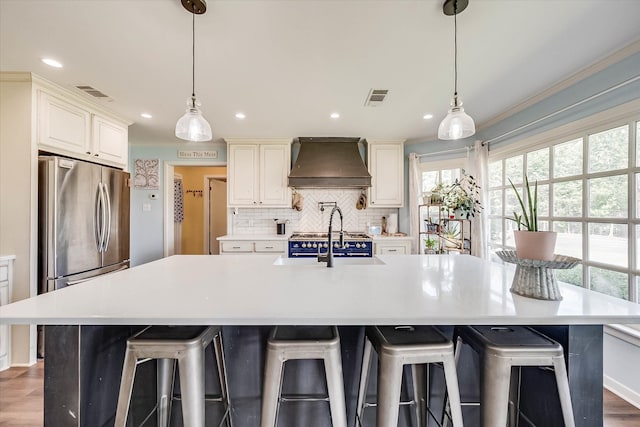 kitchen with dark hardwood / wood-style flooring, a spacious island, custom range hood, and hanging light fixtures