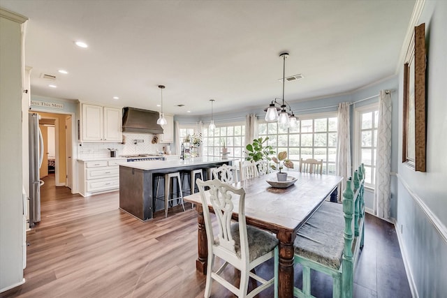 2225 W Park Ave, Corsicana, TX 75110 - dining space featuring plenty of natural light, light wood-style floors, recessed lighting, crown molding, and a chandelier