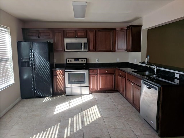 kitchen featuring light tile patterned flooring, appliances with stainless steel finishes, and sink