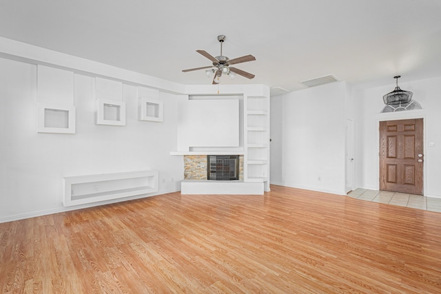 unfurnished living room featuring ceiling fan and light wood-type flooring