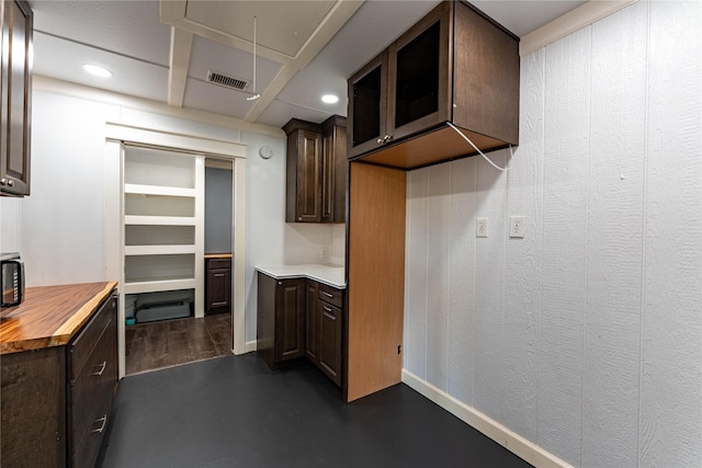 kitchen with butcher block countertops and dark brown cabinets