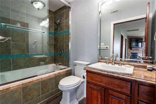 full bathroom featuring shower / bath combination with glass door, vanity, and toilet