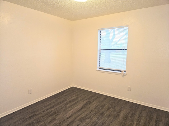 spare room with a textured ceiling and dark wood-type flooring