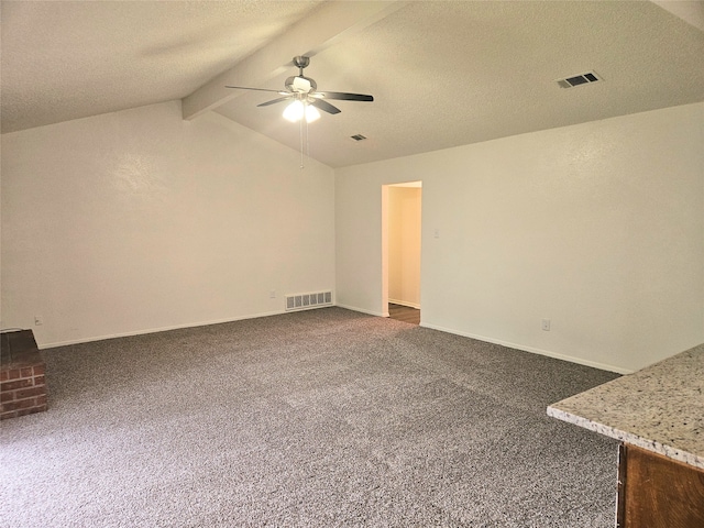 carpeted empty room with a textured ceiling, vaulted ceiling with beams, and ceiling fan