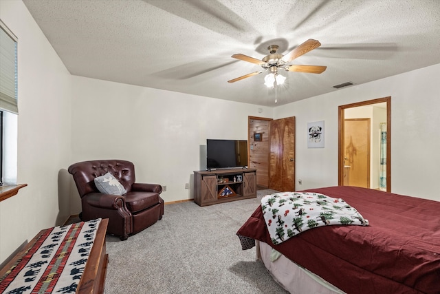 bedroom with ceiling fan, light colored carpet, and a textured ceiling