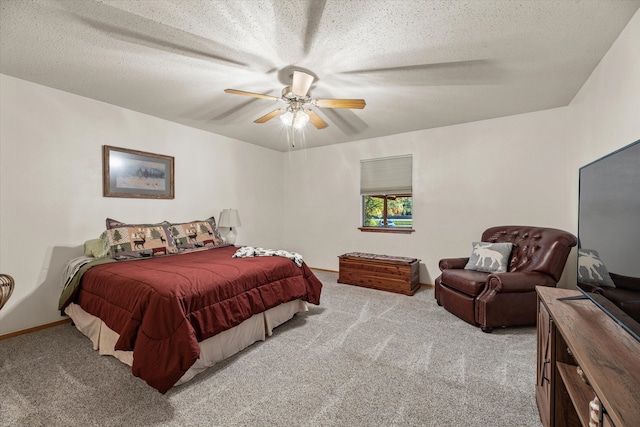 bedroom with ceiling fan, a textured ceiling, and light carpet