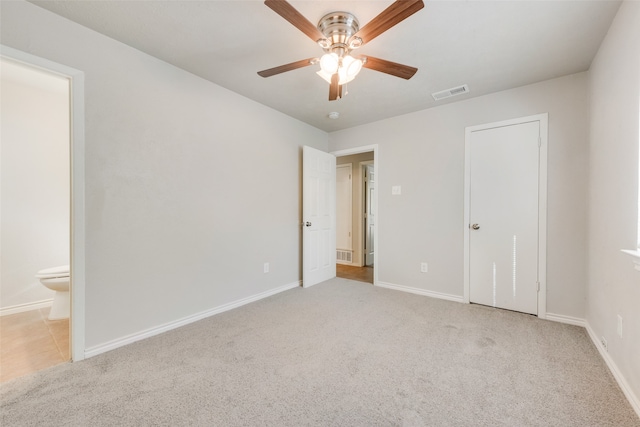 unfurnished bedroom featuring connected bathroom, light colored carpet, and ceiling fan