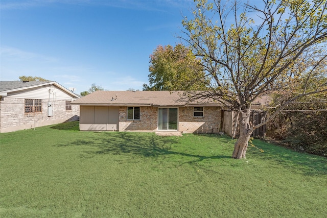 rear view of property featuring a lawn