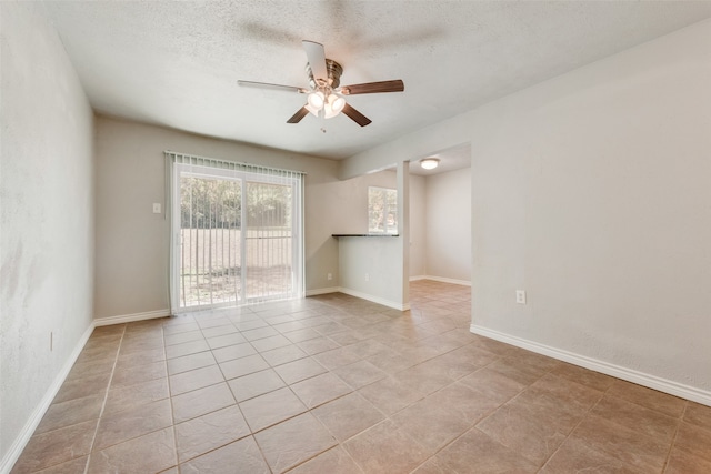 unfurnished room featuring a textured ceiling, ceiling fan, and light tile patterned flooring