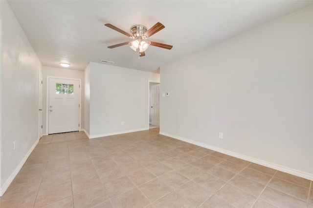 tiled spare room featuring ceiling fan