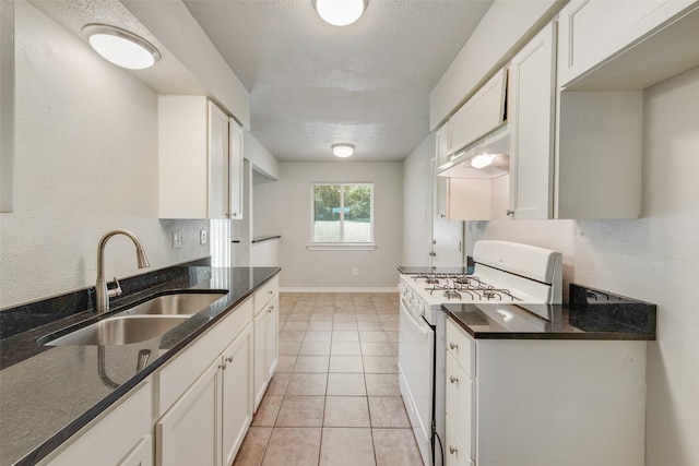 kitchen with gas range gas stove, sink, white cabinets, and dark stone counters