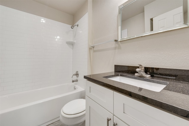 full bathroom featuring vanity, tiled shower / bath combo, and toilet