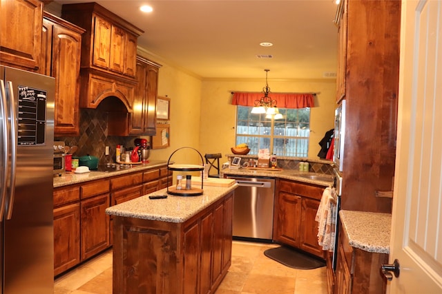 kitchen featuring pendant lighting, a center island, light stone countertops, and stainless steel appliances