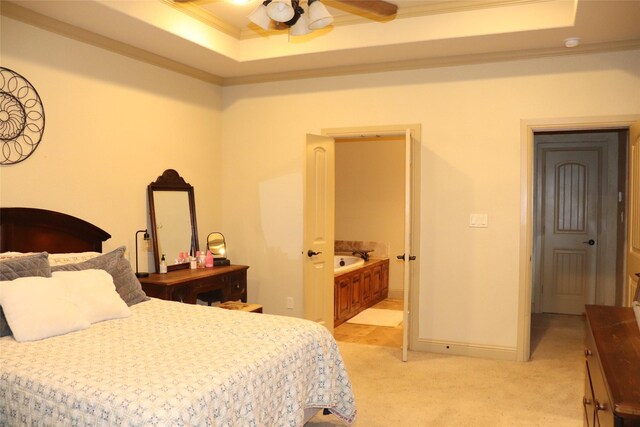 carpeted bedroom with a tray ceiling, ensuite bath, ceiling fan, and ornamental molding