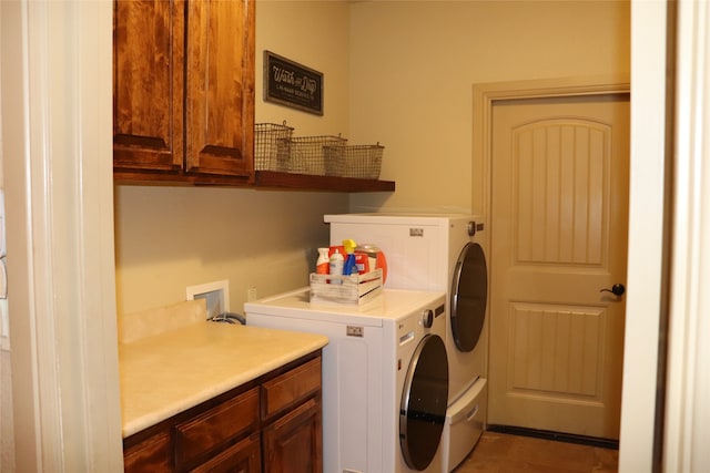 clothes washing area featuring tile patterned floors, cabinets, and independent washer and dryer